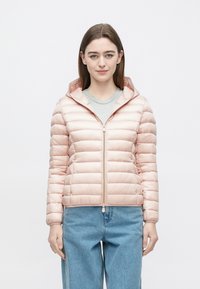 Polstret lyserød jakke med hætte, med lynlås foran og ribbet manchet. Båret over en lysegrå skjorte og kombineret med blå jeans.