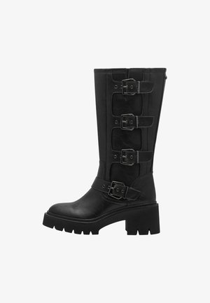 Botte noire jusqu'au genou en cuir lisse, dotée de quatre boucles métalliques réglables, d'une semelle épaisse et d'un design à bout arrondi.