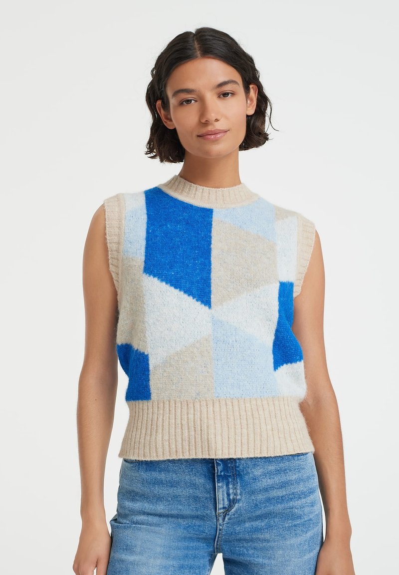 Knit sleeveless sweater featuring geometric patterns in shades of blue and beige, with a ribbed neckline and hem, made from soft material.