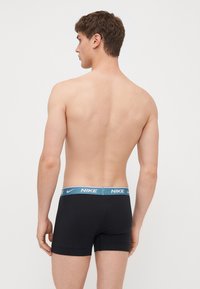 Fekete boxeralsó világoskék Nike derékkal, szoros illeszkedéssel és sima textúrával. A dizájn egyszerű és funkcionális.