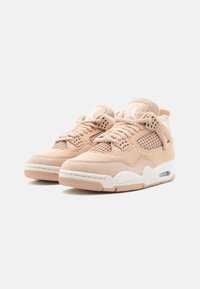 Tan suede sneakers feature a mesh design, white accents, textured laces, and a visible Air unit in the sole.