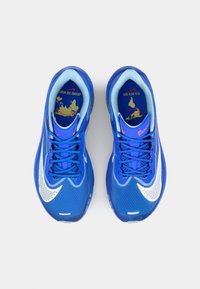 Mėlyni sportiniai bateliai su tinklelio medžiaga, ryškus baltas Nike logotipas ir kontrastuojanti šviesiai mėlyna apdaila. Raitytas padas, batraiščiai įskaičiuoti.
