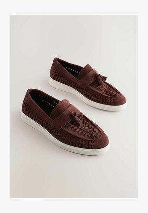 Hnědé semišové slip-on boty s tkanými detaily, plochou bílou podrážkou a předními třásněmi; hladký povrch s kulatým tvarem.