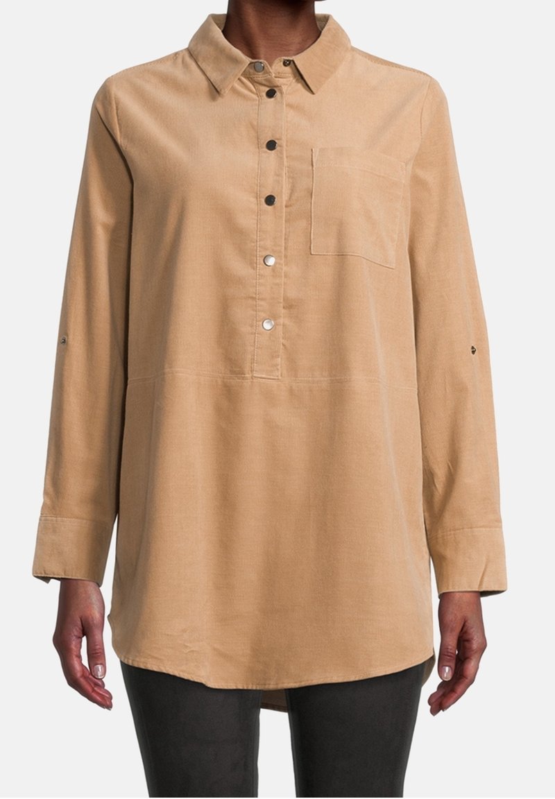 Långärmad, lätt skjorta i tan-färgad tyg, med knappslå framtill, krage, bröstficka och knappar på ärmsluten. Slät textur.