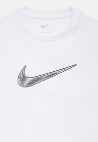 Camiseta blanca Dri-FIT con un gran logo negro de Nike Swoosh con detalles lineales. Material suave y diseño con cuello redondo.