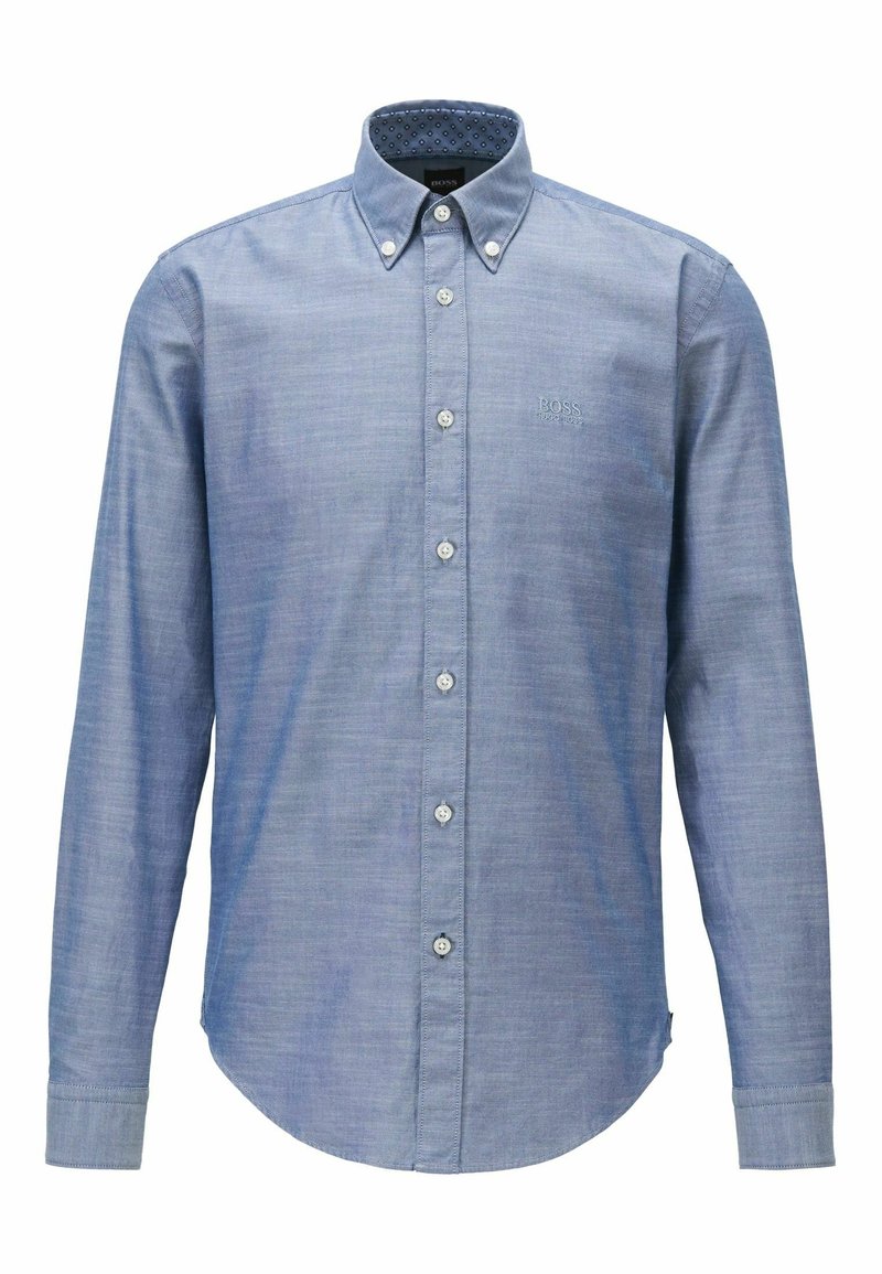 Skjorta med knappar i ljusblått tyg, med långa ärmar, rundad fåll och vita knappar. Insidan av kragen har ett prickigt mönster och en märkeslogga.