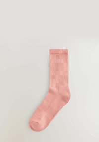 Lyserød ribbet bomuldsstrømpe med en ensfarvet tekstur. Har et logo broderet nær kanten. Fuld længde design med rund tå.