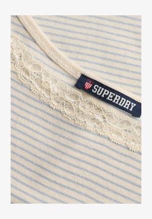Striped light blue and white fabric with cream lace trim and a navy Superdry brand label featuring a shield emblem.
