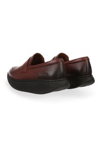 Scarpe slip-on in pelle marrone con punta arrotondata, soletta imbottita e suola in gomma nera con dettagli testurizzati.