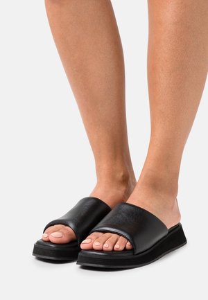Černé kožené skluzové sandály se širokým páskem, otevřenou špičkou a silnou černou platformou. Hladký povrch bez viditelných vzorů.