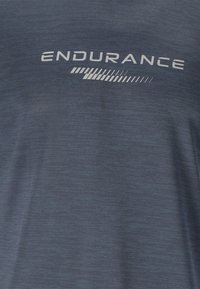 Tissu gris foncé texturé avec le mot "ENDURANCE" et un motif rayé imprimé en gris clair sur la zone de la poitrine.