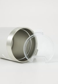 Copo térmico de aço inoxidável em cinza claro com uma borda prateada e uma tampa de plástico transparente com design de pega. O interior é liso e metálico.