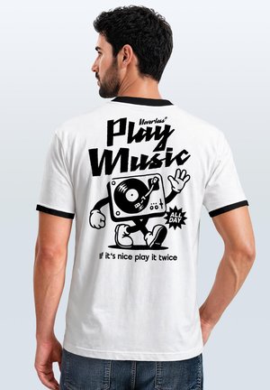 Man with dark hair and beard wearing a white T-shirt with black trim showing a walking turntable graphic and text about playing music.