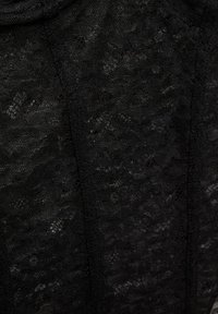 Fekete csipke anyag, aprólékos mintákkal és texturált felülettel. Az anyag könnyűnek és finomnak tűnik.