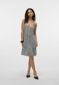 Sukienka A-line bez ramiączek z pionowymi czarno-białymi paskami, z przodem zapinanym na guziki, wielowarstwowym dołem i lekkim materiałem.