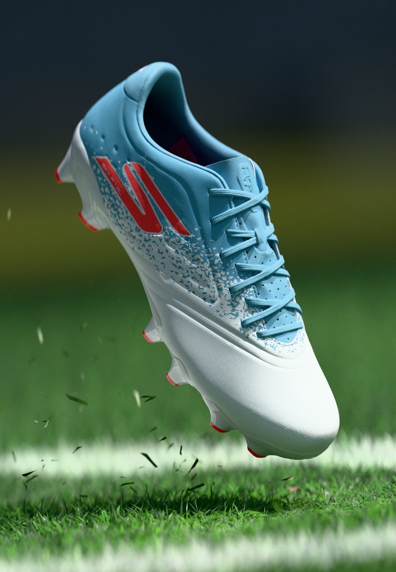 Blue and white soccer cleat with red accents, airborne above grass field with white line and scattered grass clippings.