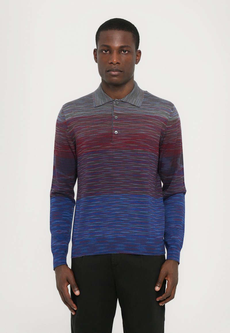 Camisola de polo de manga longa em malha com um design em degradê com riscas vermelhas, azuis e cinzentas, um colarinho e um fecho de três botões.