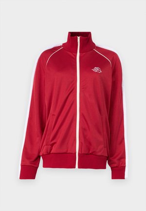 Chaqueta roja con cremallera y cuello alto, con acentos blancos en los hombros, dos bolsillos frontales y puños y dobladillo de canalé. Presenta un logo bordado en el pecho.