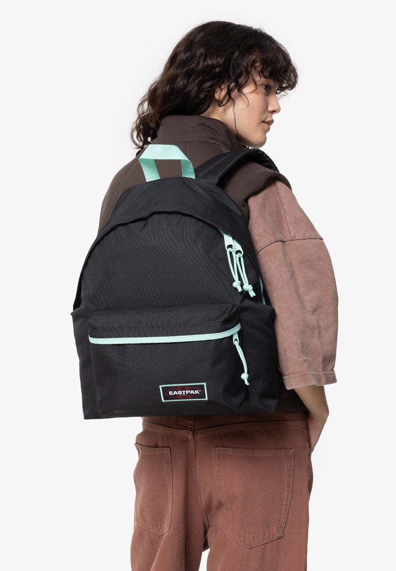 Czarny plecak wykonany z teksturowanej tkaniny z jasnoniebieskimi akcentami, przednia kieszeń, regulowane szelki i uchwyt u góry. Posiada etykietę z logo.