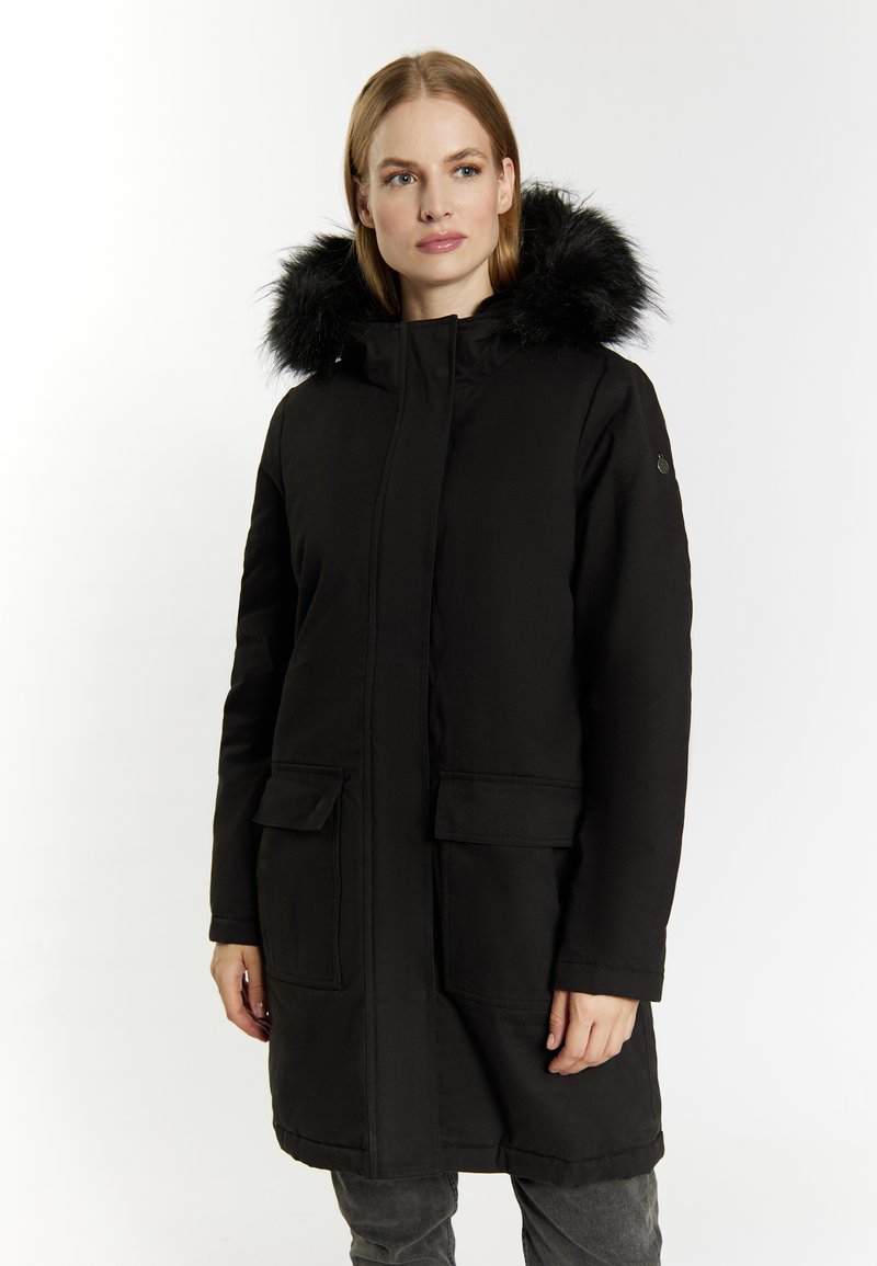 Sort lang parka-frakke med en foring af pels i hætten, der har en foran lynlås, to forlommer og et glat, tekstureret stof.