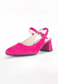 Chaussure à talon en suède rose avec un bout carré, une sangle élastique et un talon épais, présentant une texture lisse et des détails minimalistes.