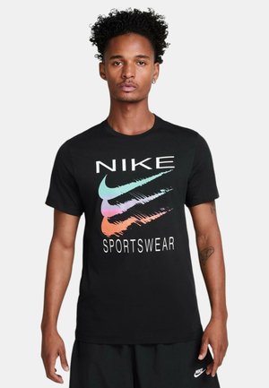 Camiseta de algodón negra con un gran logotipo de "NIKE" y tres diseños de swoosh en colores pastel. Cuello redondo y mangas cortas.