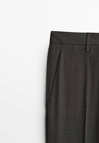 Pantaloni sartoriali grigio scuro con una texture liscia, dotati di tasche laterali e una vestibilità elegante, presentati su uno sfondo bianco puro.