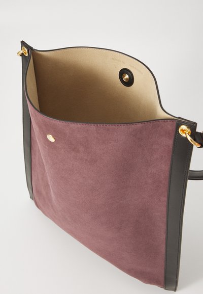 Borsa in suede color malva con rifiniture in pelle nera. L'interno presenta una texture liscia e una chiusura con calamita. Accenti dorati in vista.