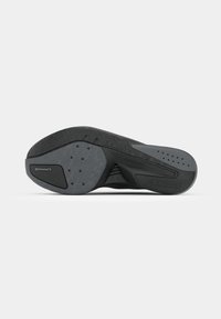 Semelle de chaussure de sport noire présentant un caoutchouc texturé, une forme épurée et une marque continentale ; inclut des motifs de grip et des trous de ventilation.