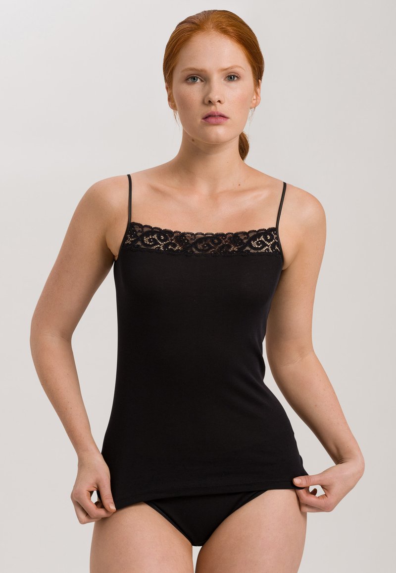 Schwarzes Cami-Top mit verstellbaren dünnen Trägern, das eine Spitzenborte am Ausschnitt aufweist. Weicher, elastischer Baumwollstoff mit tailliertem Design.