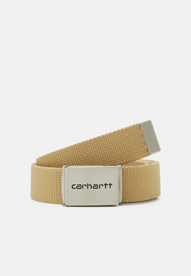 Curea din țesătură bej, împletită, cu o baretă metalică dreptunghiulară argintie, având gravat logo-ul "Carhartt". Textură netedă și design durabil.