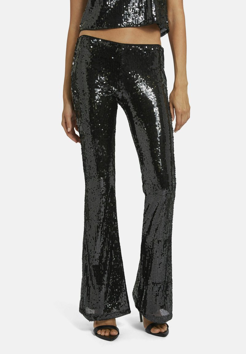Zwarte pailletten flare broek met een glanzende textuur, met een aansluitende taille en wijd broekspijpen, aangevuld met hakken sandalen.