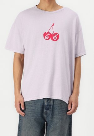 T-shirt corto a maniche corte di colore viola chiaro con una grafica di una ciliegia rossa e il numero 80 sotto, realizzata in un morbido misto cotone.