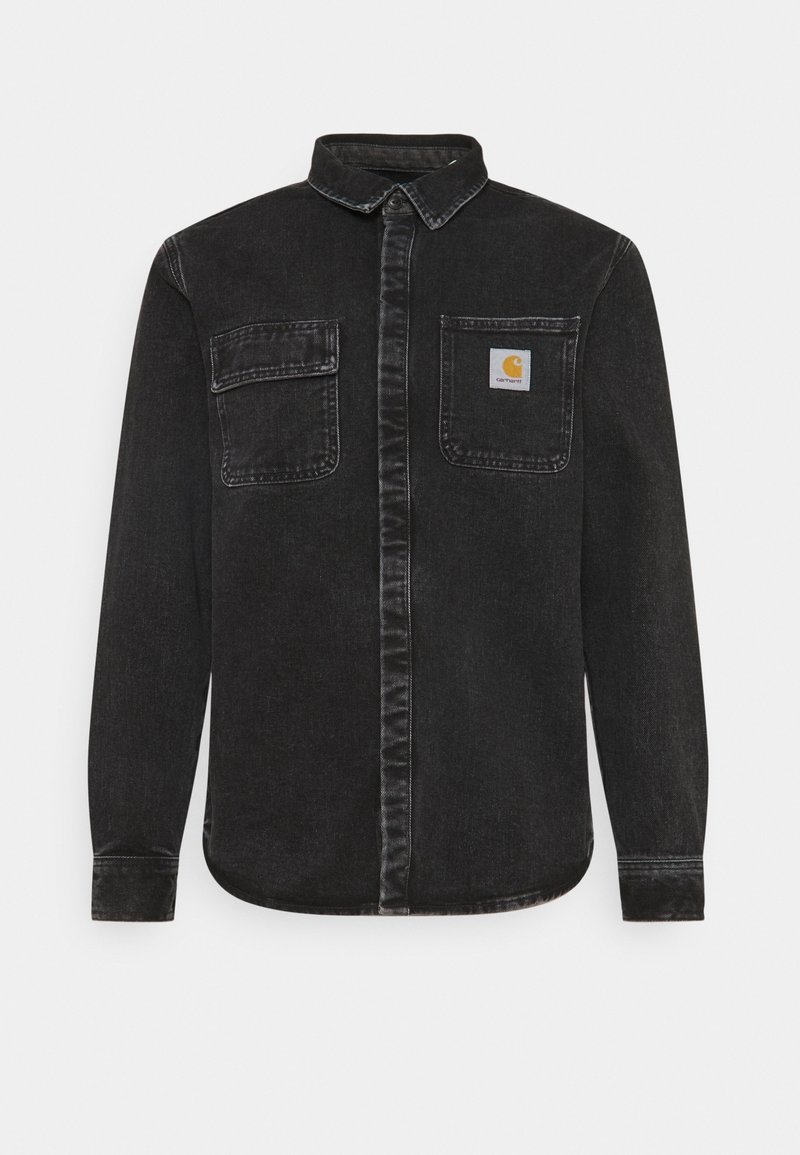 Camisa de mezclilla negra con cuello tipo botón, dos bolsillos frontales, costuras en contraste y un pequeño parche con logo en el lado izquierdo del pecho.