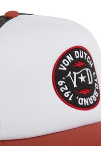 Gorra blanca con un logo redondo en rojo y negro. La parte delantera presenta un diseño estructurado, un visera curvada y una tela texturizada en la parte trasera.