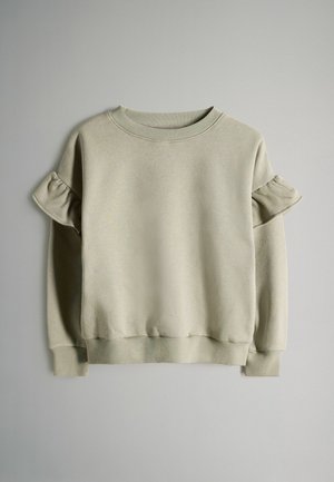 Jasnoszara bluza z okrągłym dekoltem i falbaniastymi krótkimi rękawami. Wykonana z miękkiego materiału z prążkowanymi mankietami i dołem.