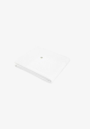 Serviette blanche pliée avec motif texturé et un petit bouton en métal sur un coin, isolée sur fond blanc.