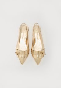 Chaussures slingback dorées à bout pointu avec une finition métallique lisse, présentant un accent froncé texturé à l'avant et un petit nœud décoratif.