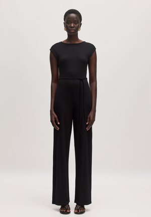 Zwarte geribbelde jumpsuit met korte mouwen, aangesloten lijfje, wijde broekspijpen en een strik in de taille, gemaakt van zachte, rekbare stof.
