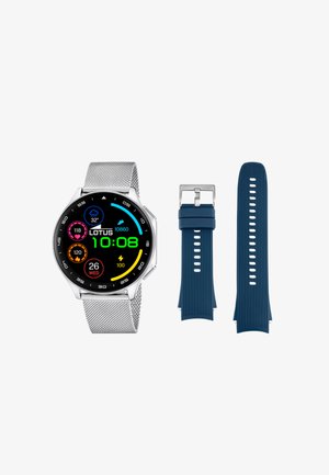 Reloj inteligente plateado con pantalla colorida que muestra información de fitness y el clima, junto a una correa adicional de silicona azul con hebilla.