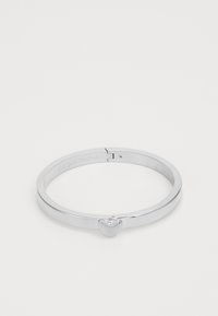 Silver bangle bracelet with a smooth, polished finish. Features a heart-shaped accent on the front and a secure clasp for closure.