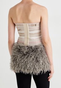 Stoffoberteil ohne Träger in Beige mit pinken Streifen, mit einer strukturierten grauen Fellverzierung an der Taille. Hinten mit Haken verschlossen.