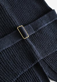 Mornarski teksturirani materijal ima horizontalni rebrasti uzorak s tkanim pojasom i zlatnim pravokutnim kopčanjem u središtu.