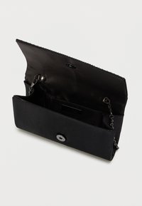 Čierna kabelka cez plece vyrobená z hladkej tkaniny, s reťazovým popruhom, zapínaním na cvok a vnútornou kapsou s jemným logom.