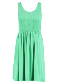 Ljusgrön ärmlös klänning med en smockad urringning och en flödande, rynkad kjol. Tillverkad av mjukt, lättviktigt tyg för komfort.