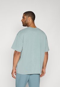 Under Armour ATHLETES  - Apdrukāts T-krekls - serpentine/jasper blue