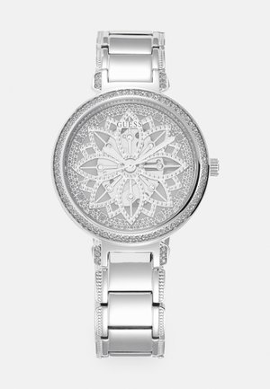 Montre en argent avec un cadran à motif floral, rehaussé de cristaux, et un bracelet en métal poli dotée de maillons et d'accents décoratifs.