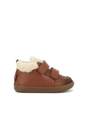 Chaussure marron pour tout-petit avec deux brides velcro, doublure douce en polaire blanche, bout en daim et semelle en caoutchouc, vue de côté sur fond blanc.