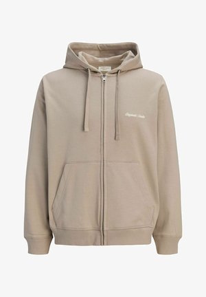 Sweat à capuche beige zippé avec poches avant, cordon de serrage à la capuche, poignets et ourlet côtelés, et petit texte blanc « Originals Studio » sur la poitrine gauche.