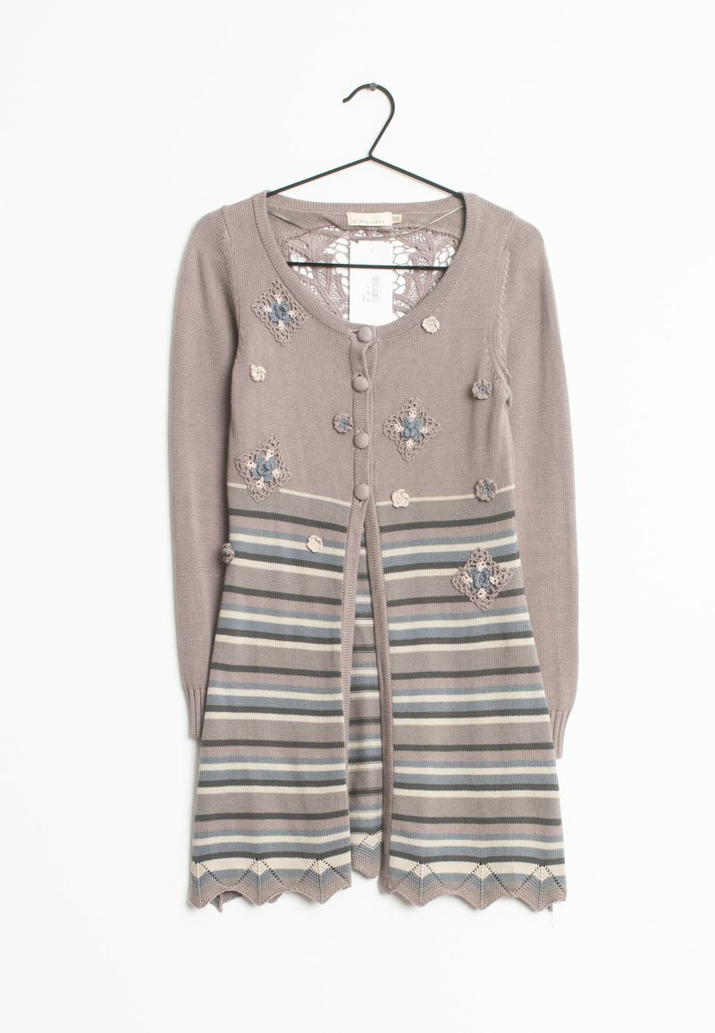 Beige cardigan med blommönsterbroderi, randig kjol, fem knappar och virkad dekoration. Har långa ärmar och dekorativ nederkant.